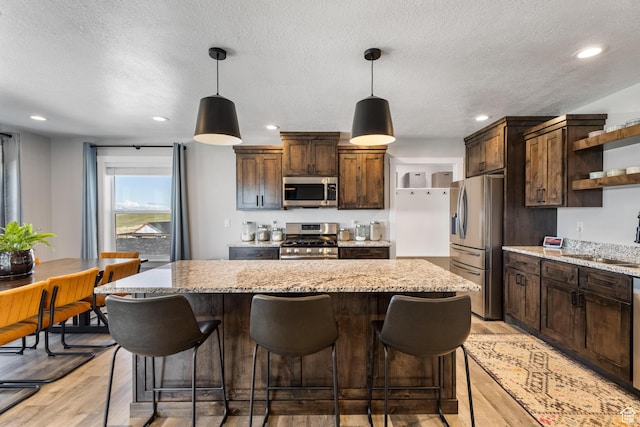 51 S 1250 E, Smithfield, UT 84335 - kitchen with open shelves, a sink, appliances with stainless steel finishes, light wood finished floors, and a kitchen island