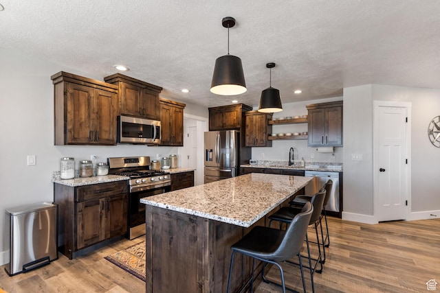 51 S 1250 E, Smithfield, UT 84335 - kitchen with light wood-style floors, appliances with stainless steel finishes, a center island, and dark brown cabinetry