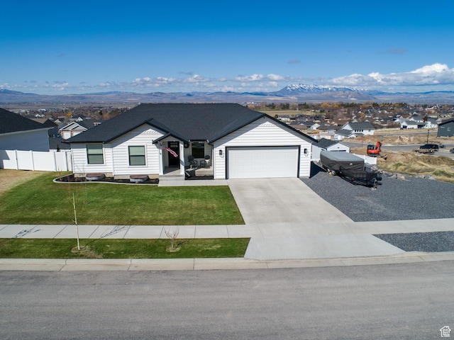 51 S 1250 E, Smithfield, UT 84335 - view of front facade with concrete driveway, a mountain view, an attached garage, a front lawn, and fence