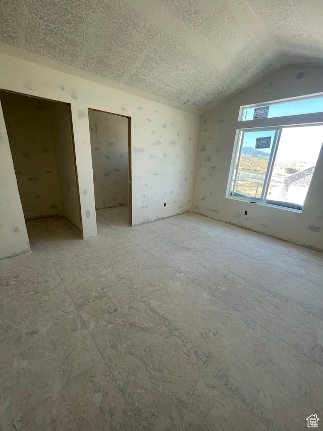 7007 W Hazel Oak Ct Unit 212, Herriman, UT 84096 - unfurnished bedroom featuring a textured ceiling and lofted ceiling