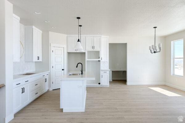7007 W Hazel Oak Ct Unit 212, Herriman, UT 84096 - kitchen featuring light wood-style floors, a chandelier, and white cabinetry