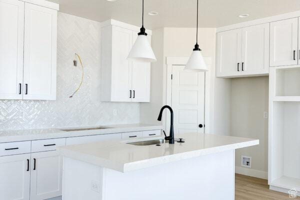 7007 W Hazel Oak Ct Unit 212, Herriman, UT 84096 - kitchen with tasteful backsplash, an island with sink, white cabinetry, and recessed lighting