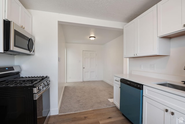 924 W California Ave, Salt Lake City, UT 84104 - kitchen with baseboards, light countertops, white cabinetry, stainless steel appliances, and a sink