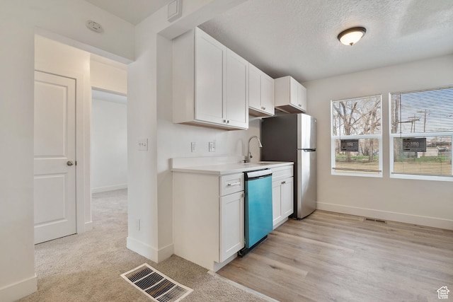 924 W California Ave, Salt Lake City, UT 84104 - kitchen with freestanding refrigerator, dishwashing machine, visible vents, light countertops, and a sink