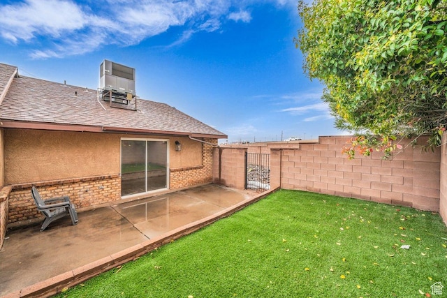 view of yard featuring a patio, central AC unit, and fence