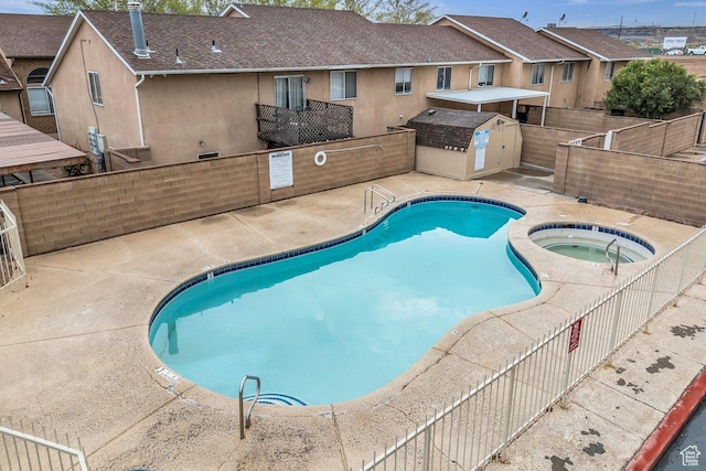pool featuring a fenced backyard, a patio, and a community hot tub