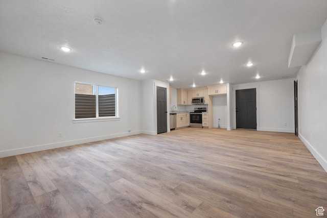 unfurnished living room featuring visible vents, baseboards, light wood-type flooring, and recessed lighting