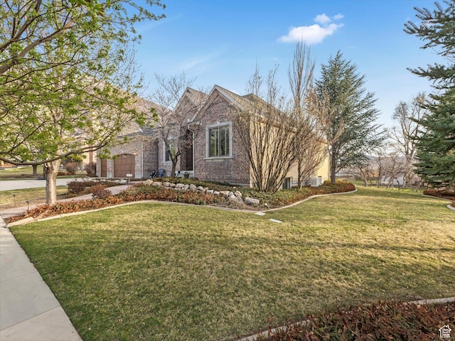 view of front of home featuring an attached garage, driveway, a front lawn, and brick siding