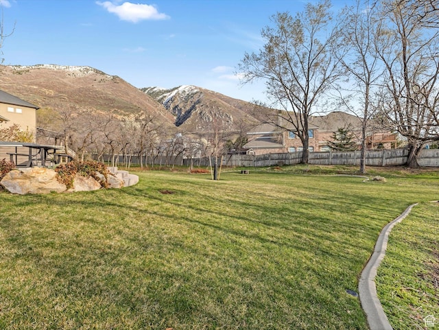 view of yard featuring a mountain view and fence