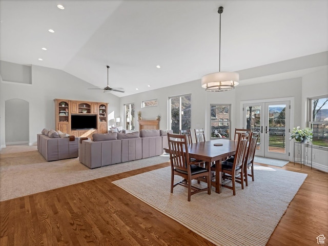 dining area featuring a ceiling fan, wood finished floors, baseboards, french doors, and arched walkways