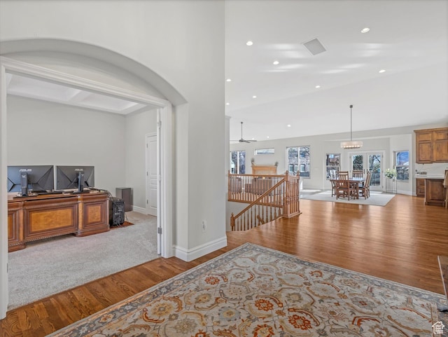foyer entrance featuring recessed lighting, lofted ceiling, wood finished floors, and a notable chandelier