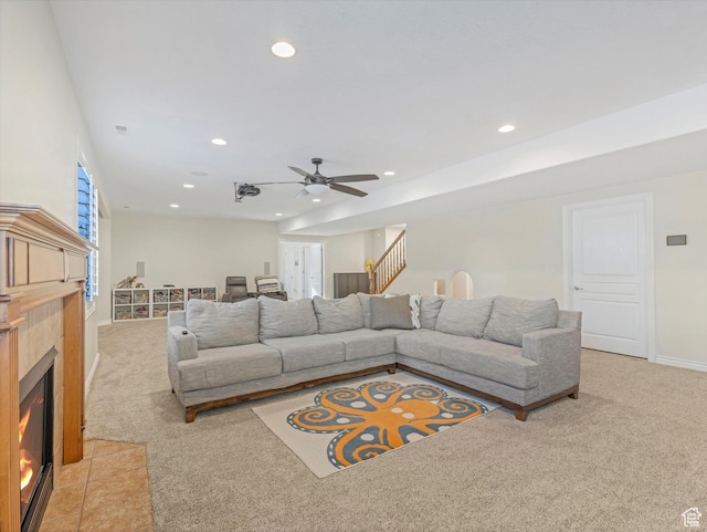 living room featuring a ceiling fan, light colored carpet, a fireplace, baseboards, and recessed lighting