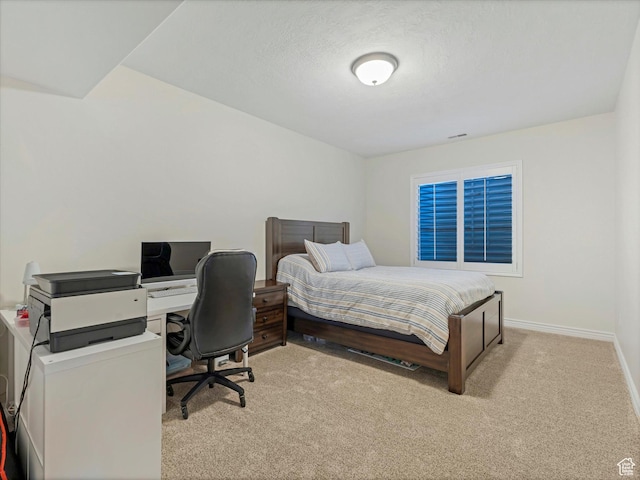 bedroom with baseboards and light carpet
