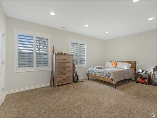 carpeted bedroom featuring recessed lighting, baseboards, visible vents, and multiple windows