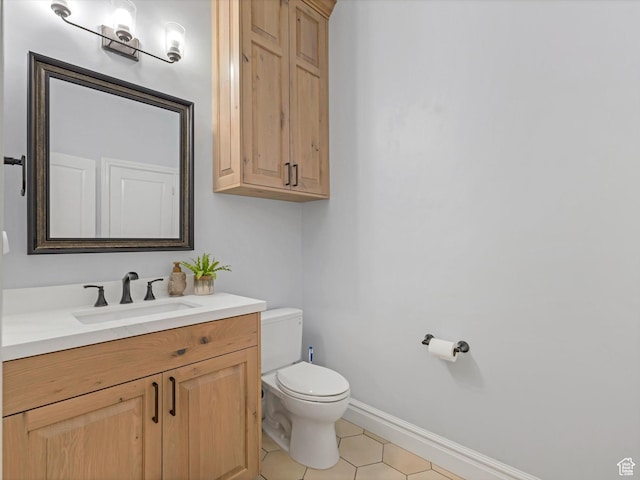 bathroom with toilet, baseboards, tile patterned flooring, and vanity