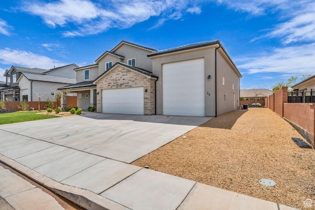 39 W Elinor Ln, Washington, UT 84780 - view of front of property featuring stucco siding, fence, stone siding, an attached garage, and concrete driveway