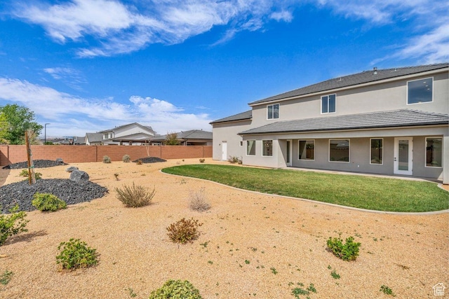 39 W Elinor Ln, Washington, UT 84780 - back of house with a fenced backyard, stucco siding, and a lawn
