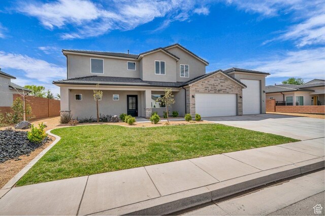 39 W Elinor Ln, Washington, UT 84780 - traditional-style home with stucco siding, a front yard, fence, an attached garage, and driveway