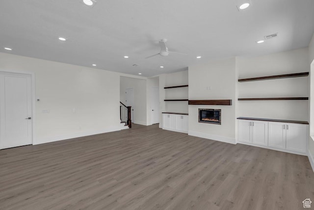 39 W Elinor Ln, Washington, UT 84780 - unfurnished living room with visible vents, a ceiling fan, recessed lighting, light wood-style flooring, and a glass covered fireplace