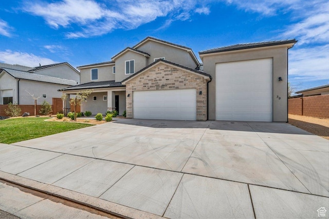 39 W Elinor Ln, Washington, UT 84780 - view of front of home with stucco siding, fence, a front lawn, an attached garage, and driveway