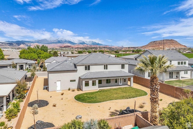 39 W Elinor Ln, Washington, UT 84780 - rear view of property featuring a mountain view, a fenced backyard, a tile roof, stucco siding, and a residential view