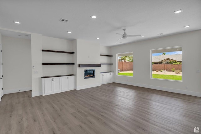 39 W Elinor Ln, Washington, UT 84780 - unfurnished living room featuring a glass covered fireplace, baseboards, recessed lighting, light wood-style floors, and ceiling fan