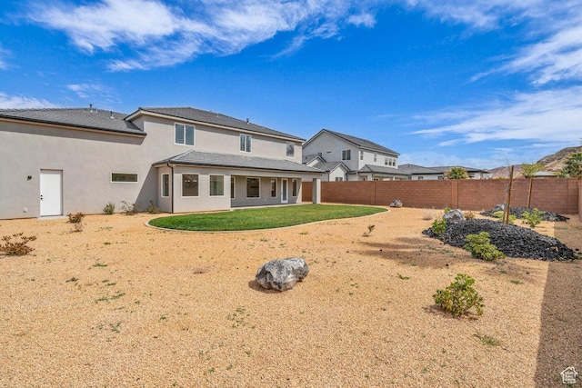 39 W Elinor Ln, Washington, UT 84780 - rear view of property featuring a yard, a fenced backyard, and stucco siding
