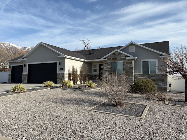 view of front of home featuring an attached garage, stone siding, stucco siding, and driveway
