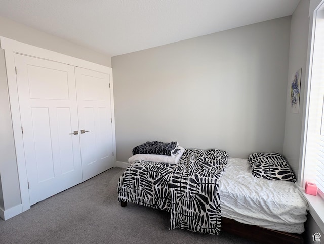 bedroom featuring baseboards, carpet, and a closet