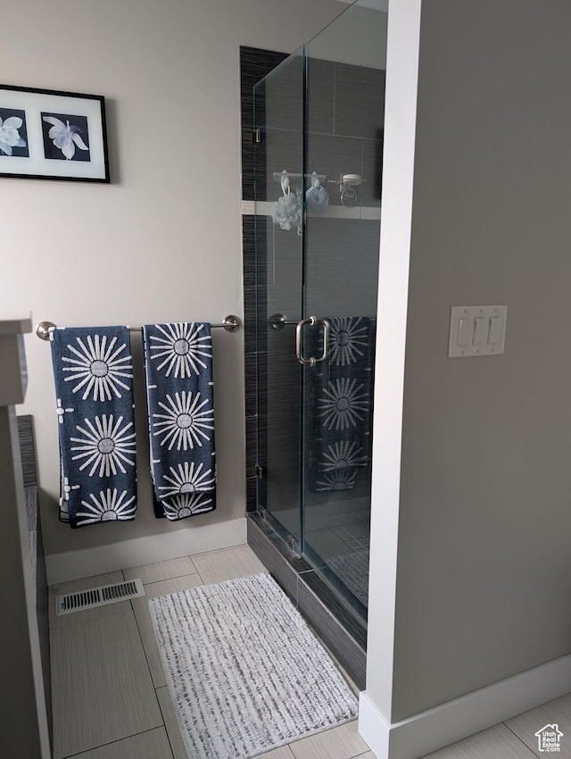 bathroom with baseboards, tile patterned flooring, visible vents, and a stall shower