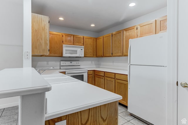 kitchen with a sink, light countertops, white appliances, a peninsula, and light tile patterned flooring