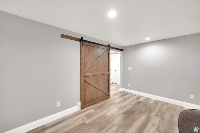 2282 N 3430 W, Clinton, UT 84015 - unfurnished bedroom with a barn door, light wood finished floors, and recessed lighting