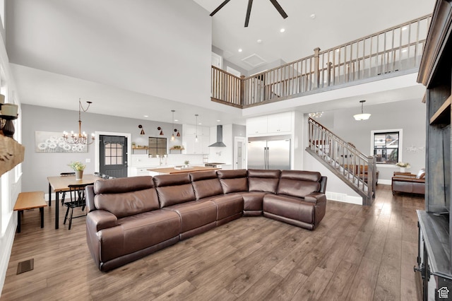 2282 N 3430 W, Clinton, UT 84015 - living area with ceiling fan, stairs, a high ceiling, wood finished floors, and a chandelier