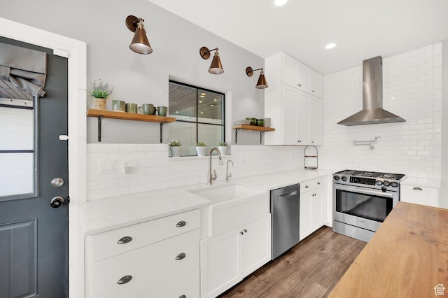 2282 N 3430 W, Clinton, UT 84015 - kitchen featuring wall chimney range hood, stainless steel appliances, open shelves, backsplash, and dark wood finished floors