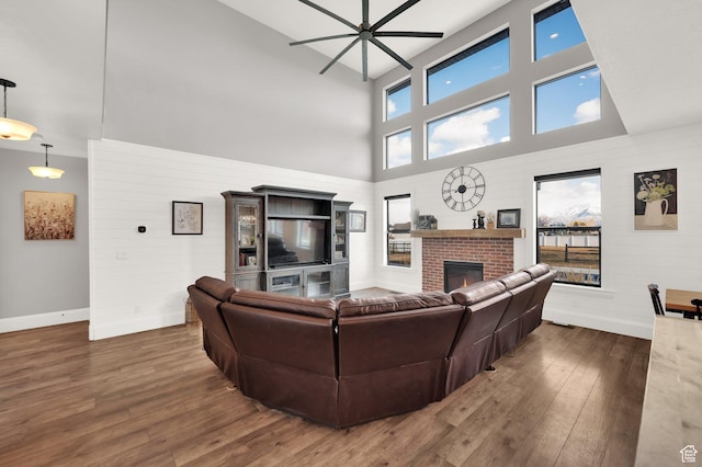 2282 N 3430 W, Clinton, UT 84015 - living room featuring a towering ceiling, a ceiling fan, wood finished floors, and a fireplace