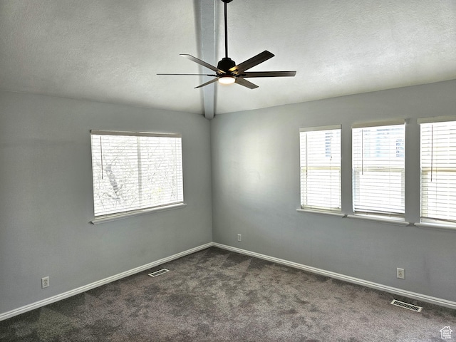 unfurnished room featuring visible vents, a ceiling fan, and dark colored carpet