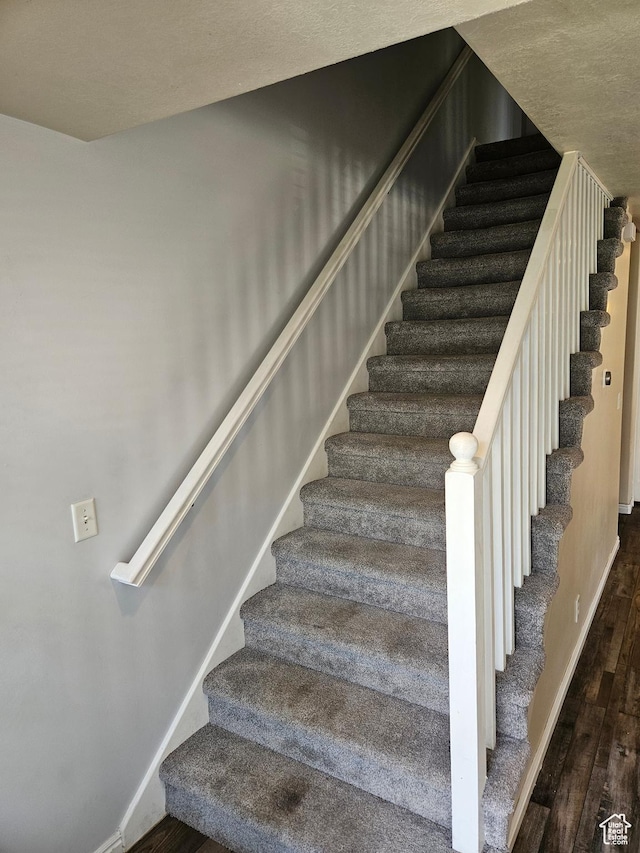 stairway featuring wood finished floors and baseboards