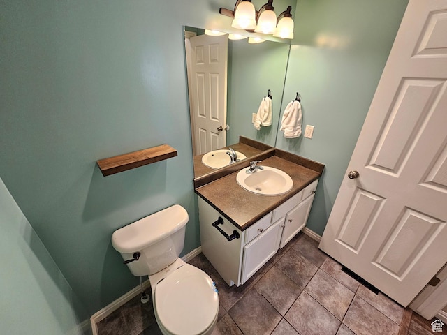 bathroom featuring baseboards, an inviting chandelier, toilet, vanity, and tile patterned floors