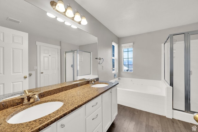 full bath featuring a shower stall, a garden tub, a sink, and visible vents