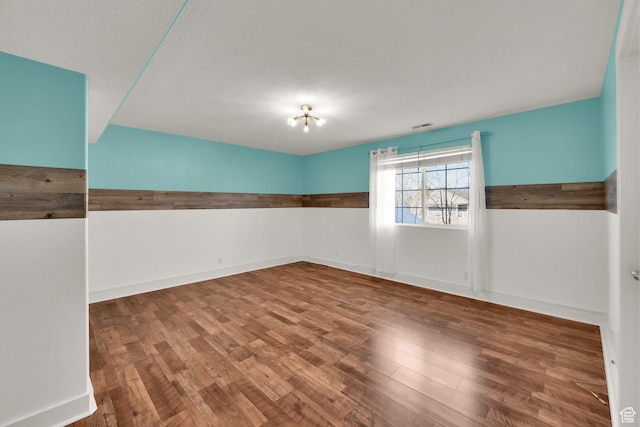 spare room with wood finished floors and baseboards