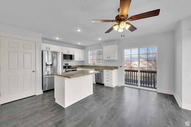 kitchen featuring ceiling fan, dark wood finished floors, white cabinetry, stainless steel appliances, and a kitchen island