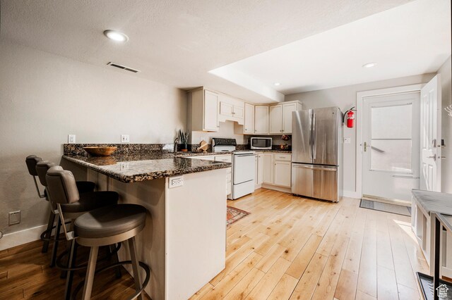 872 Martingale Ln, Park City, UT 84098 - kitchen featuring a peninsula, appliances with stainless steel finishes, visible vents, and light wood-style floors