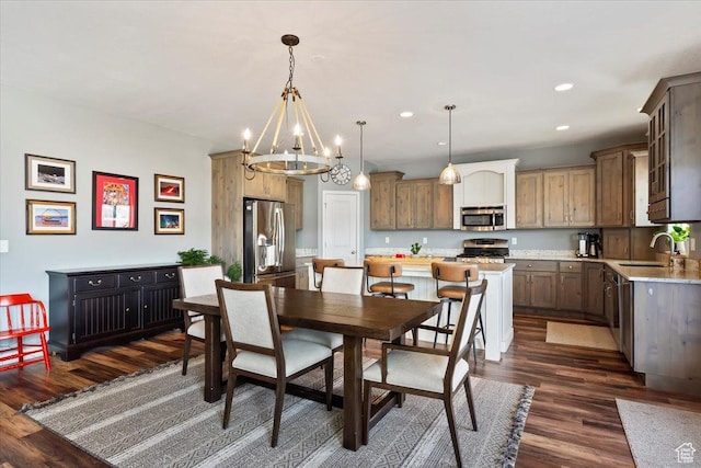 dining room with dark wood-type flooring, recessed lighting, and an inviting chandelier