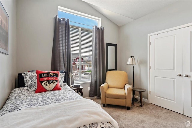 bedroom with light carpet and vaulted ceiling