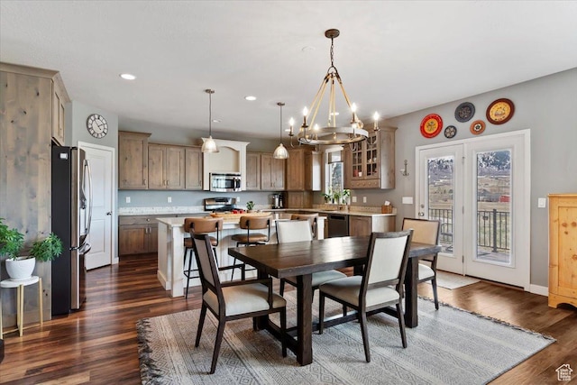 dining space with recessed lighting, dark wood-style floors, baseboards, and an inviting chandelier