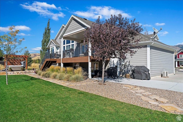 rear view of property with a yard, a deck, and a pergola