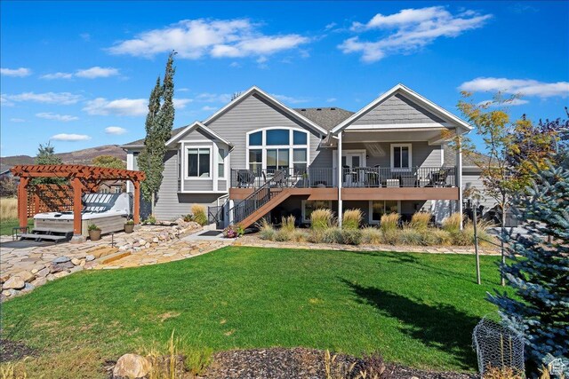 rear view of property with stairway, a pergola, a hot tub, and a lawn