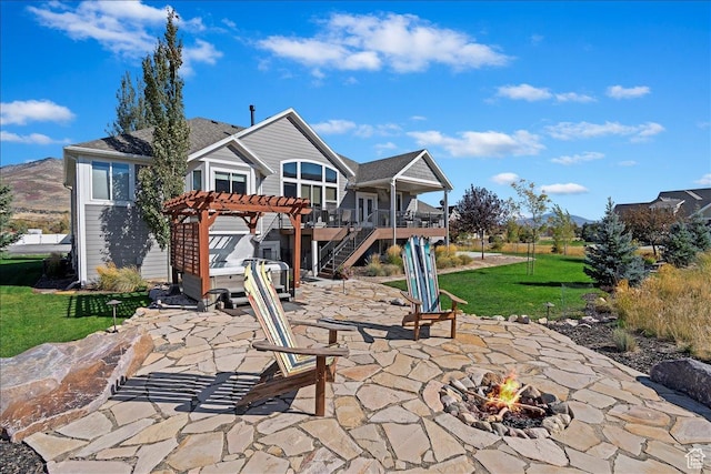rear view of house featuring a pergola, a fire pit, a patio area, stairs, and a lawn