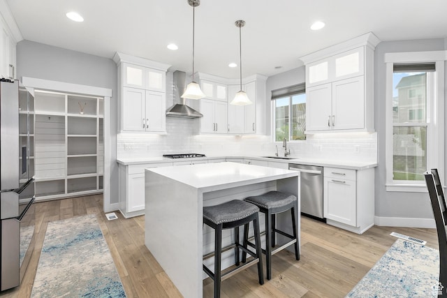 2913 S Puddle Ln, Saratoga Springs, UT 84045 - kitchen featuring wall chimney exhaust hood, stainless steel appliances, a sink, and white cabinetry