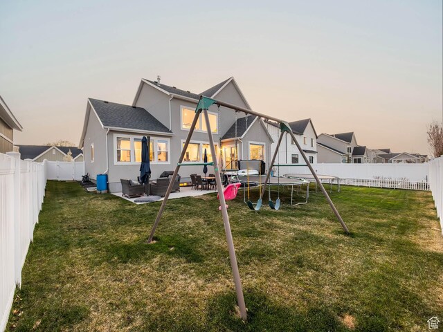 667 S Meade St, Mapleton, UT 84664 - back of property at dusk featuring a yard, a fenced backyard, and a trampoline